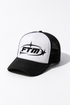 A black and white trucker hat with a white front panel, black brim, and black mesh back, featuring a black &